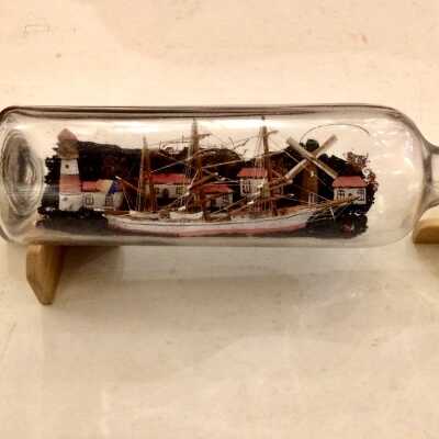 Ship model in bottle with village with windmill and lighthouse, of Fred Krueger