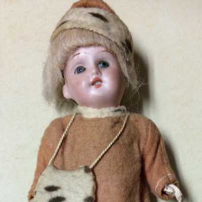 Doll with red cotton dress, hat and muff with imitation ermine trim, c. 1910-1915