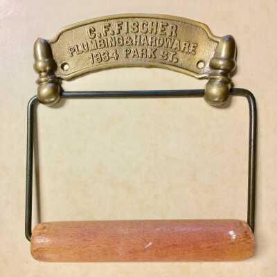 Advertising toilet paper holder from C. F. Fisher, Plumbing & Hardware, after 1909
