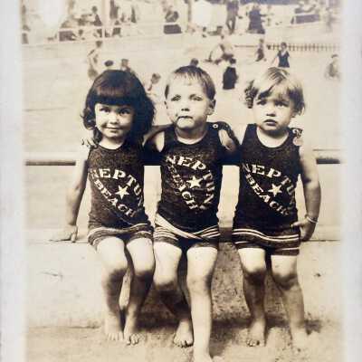 Photo postcard of three children in Neptune Beach bathing suits, 1918