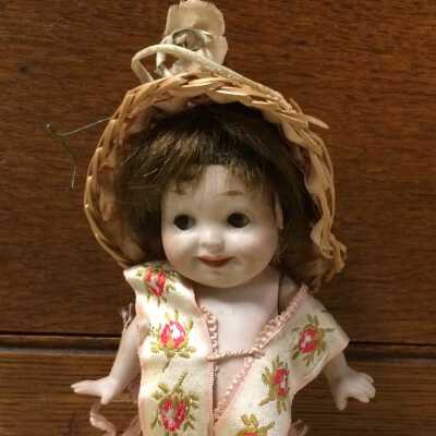 All bisque Googley-Eyed doll with silk ribbon dress and straw hat, c. 1910-1912