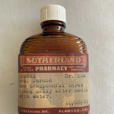 Two-seam dark amber glass medicine bottle from Sutherland Pharmacy, 1951