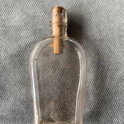 Coffin-shaped double seamed clear glass pocket whiskey flask, c. 1900s