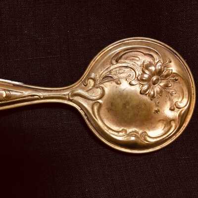 Child's brass hand mirror with reposé flowers and filigree, ealry 1900s