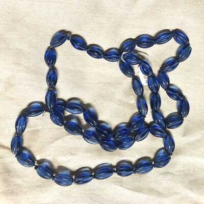 Fluted blue colored glass beads on blue knotted string, c. 1920
