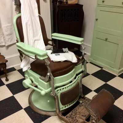Pedestal-mounted revolving hydraulic barber chair of pale green enameld iron, 1930s