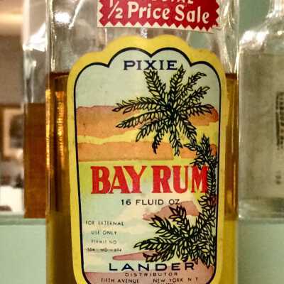 Clear glass bottle of Bay Rum, with contents, from Frank's Barber Shop