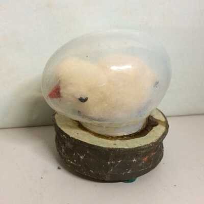 Cotton covered chick in celluloid egg, on circular base with squeak box.