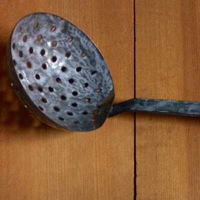 Long-handled pierced spoon in graniteware, c. 1920