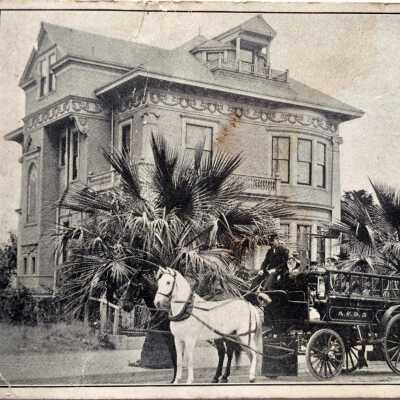 Photo postcard of F. W. Hartley in uniform, with ladder truck, and Sevening Mansion, early 1900s