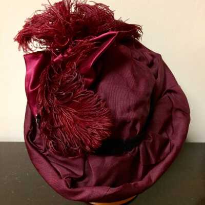 Burgundy silk hat with velvet band and satin bow and plumes