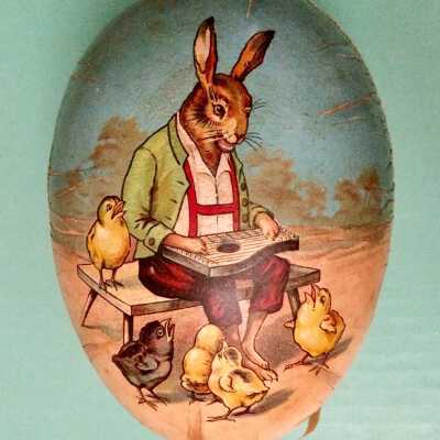 Cardboard egg decorated with rooster with chicks and a zither playing rabbit, c. 1912