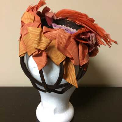 Brown felt framed cocktail hat with coral feathers, ribbons, and flowers, 1940s