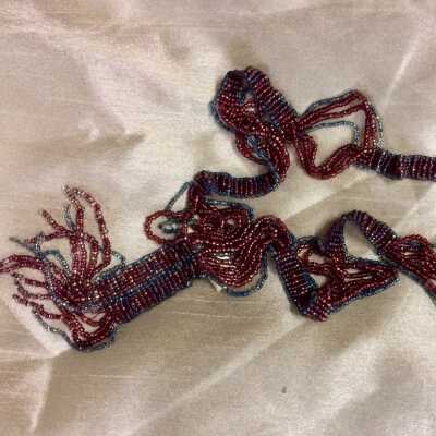 Necklace of red and blue glass woven beads with pendant, c 1920s