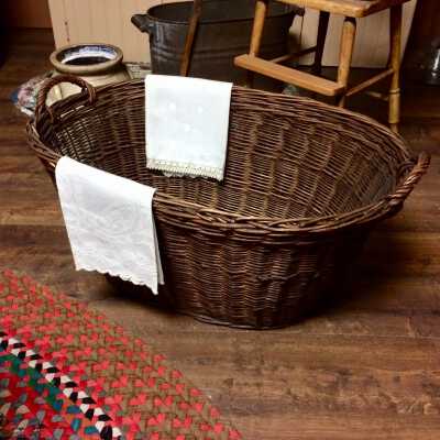 Handwoven oval reed laundry basket with two handles, pre-1937
