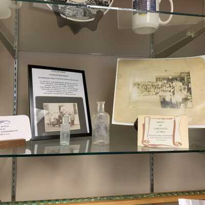 Various Artifacts and Photos Display - Left Side Close Up 2nd Shelf: Various Artifacts and Photos Display - Left Side Close Up 2nd Shelf.  Includes a pill bottle from Stephentown, Glass Lake School photo, and Faith Mills Employees Photo.