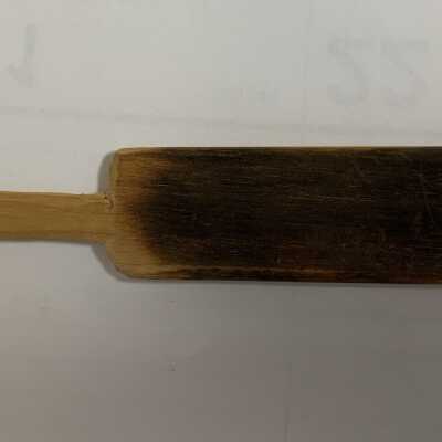 Glass Making Paddle - Small: A paddle is a wooden board with handle used for flattening glass, particularly the base or foot of a vessel. A paddle becomes charred with use against hot glass. Occasionally, a glassmaker’s assistant will protect the glassmaker from excess radiant heat by using the paddle as a shield.