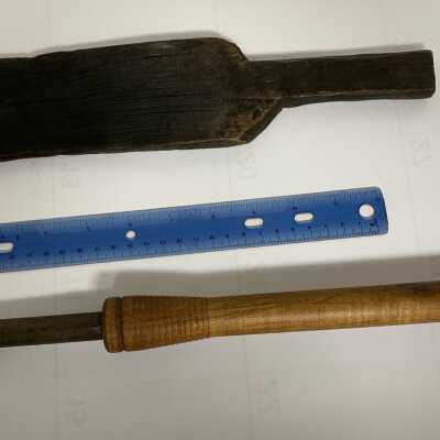 Glass Making Paddle - Large With Scale and Unknown Tool: A paddle is a wooden board with handle used for flattening glass, particularly the base or foot of a vessel. A paddle becomes charred with use against hot glass. Occasionally, a glassmaker’s assistant will protect the glassmaker from excess radiant heat by using the paddle as a shield.  The use of the other tool is uncertain.