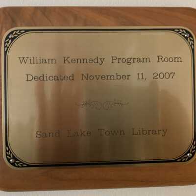 Commemorative Plaque - William Kennedy Program Room Dedication: Commemorative Plaque - William Kennedy Program Room currently hanging in the Town Library, Town of Sand Lake, NY.  Owned by the TOSL Library.
