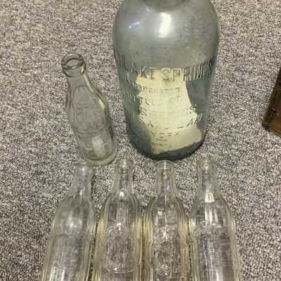 The one 5 pint bottle and 5 soda bottles stored in Sand Lake Springs Box Type 2: The one 5 pint bottle and 5 soda bottles stored in Sand Lake Springs Box Type 2.  The 5 soda bottles are solely stored in the box for safe keeping.  The 2nd floor large in wall historic display of various artifacts includes a six pack carrier / caddy for soda bottles.