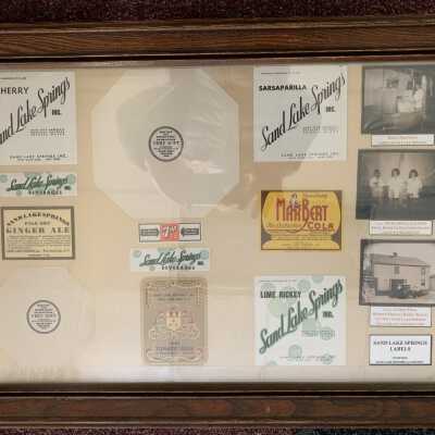 Sand Lake Springs Label Display - Photo 2: Sand Lake Springs Label Display - Hanging on wall near Sand Lake Springs Cabinet Display as of February 2021.