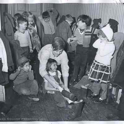 Marilyn Newberger, teacher helping children put on their boots