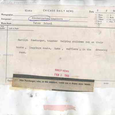 Marilyn Newberger, teacher helping children put on their boots: Back of photograph