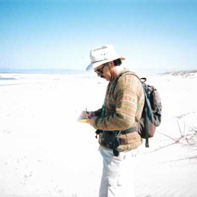 Man writing on beach in the Dunes, 8/29/2005 - 5" x 7" color photograph