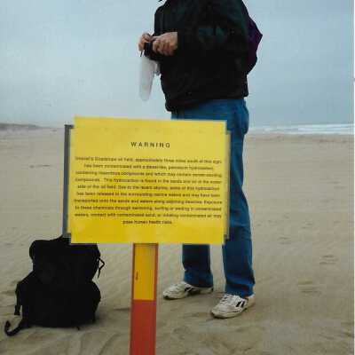 Instalation of Warning Signs concerning nearby Unocal's Guadalupe Oil Fields contamination of water and sands at Oceano Dunes SVRA, in photo album - Undated 3.5" x 5" color photograph