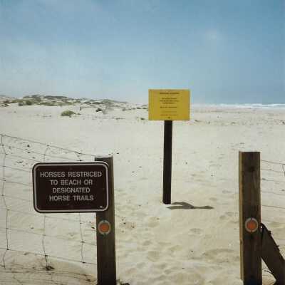 Instalation of Warning Signs concerning nearby Unocal's Guadalupe Oil Fields contamination of water and sands at Oceano Dunes SVRA, in photo album - Undated 3.5" x 5" color photograph