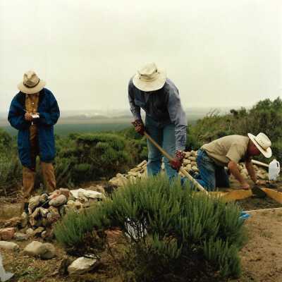 Pictures of the construction sequence of the monumnet on Coreopsis Hill for Joseph Enos and Mary Barcellos Enos for allowing people to lead hikers on their propertyto see the beautiful dune flowers, monument idea by Kathleen Goddard Jones, designed and constructed by Jack Beigle, Al Spierling, Norm Hammond, and Hal Shartz with Kathleen Goddard Jones supervising, 1994 - 4" x 4" color photograph