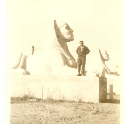 Man poses in front of 2 sphinx taken from the set of The Ten Commandments.