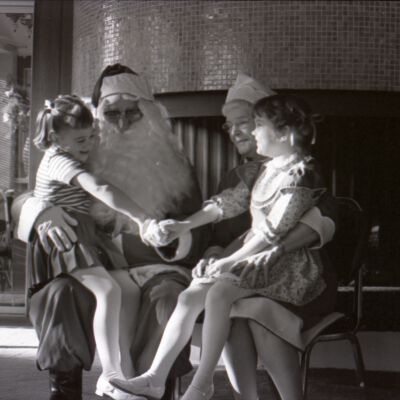 Unidentified girls sitting on Mr. and Mrs. Clause's laps, Date unknown: Frame 3f