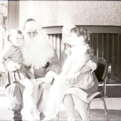 Unidentified girls sitting on Mr. and Mrs. Clause's laps, Date unknown: Frame 4f