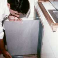 A scan of a slide showing someone removing a transparent plane