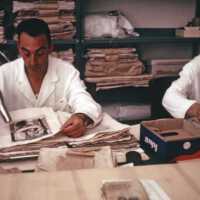 Scan of a slide showing conservators drying books