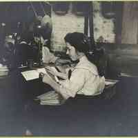 1910 Photograph of a woman hand saddle stitching a magazine