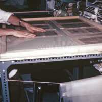 A scan of a slide showing someone laying pages on a table