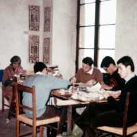 Scan of a photo showing five individuals around a table