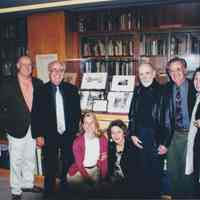 Photo of seven people gathered around a display case