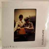 Patri and another woman lifting a sheet of paper