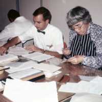 A scan of showing three conservators at work