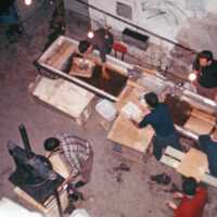 Scan of a slide showing conservators cleaning pages