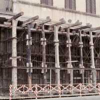 Scanned photo showing a building being braced with wood and metal
