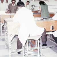 Scan of a slide showing conservators cleaning books