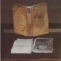 Photo of a book, title page, and print