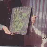Photo of Stella Patri holding a book with a marbled cover