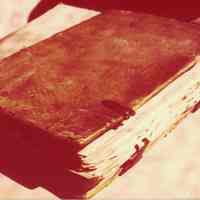 Photo of a book with metal clasps and a woven design on the cover