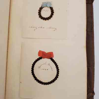 Amy Hall Williams Hair Album 1834-1844: Hair Samples from: Mary Ann Murray 1841, with blue bow; Hannah Famous 1840 with red ribbon