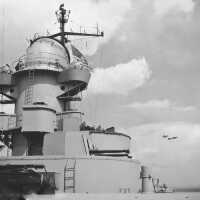 Three Kingfishers are flying in formation aft of IOWA. Note the large searchlights on the aft stack. BuAer 238830.